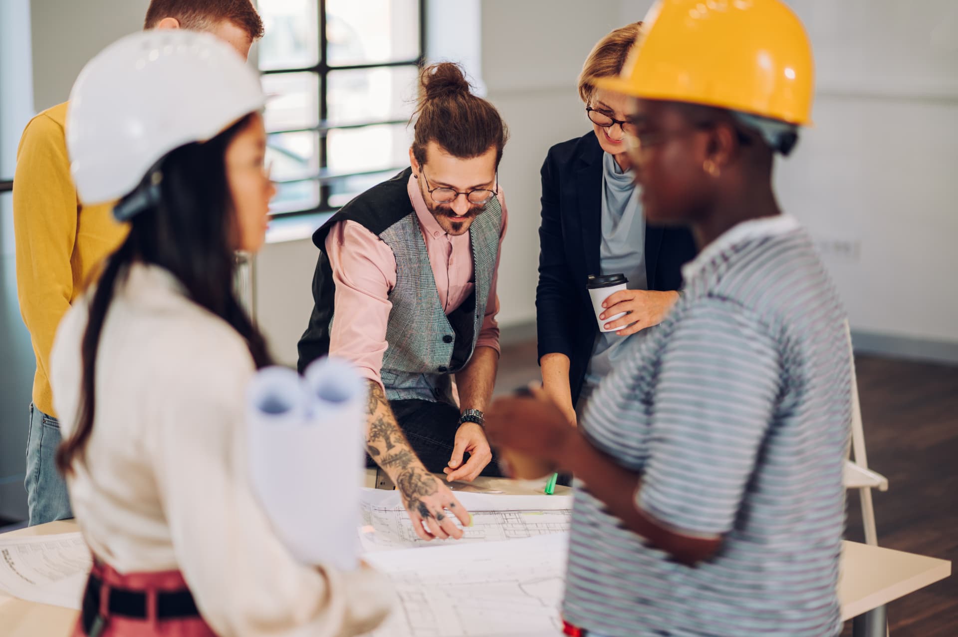 Business colleagues reviewing blueprints together at a table