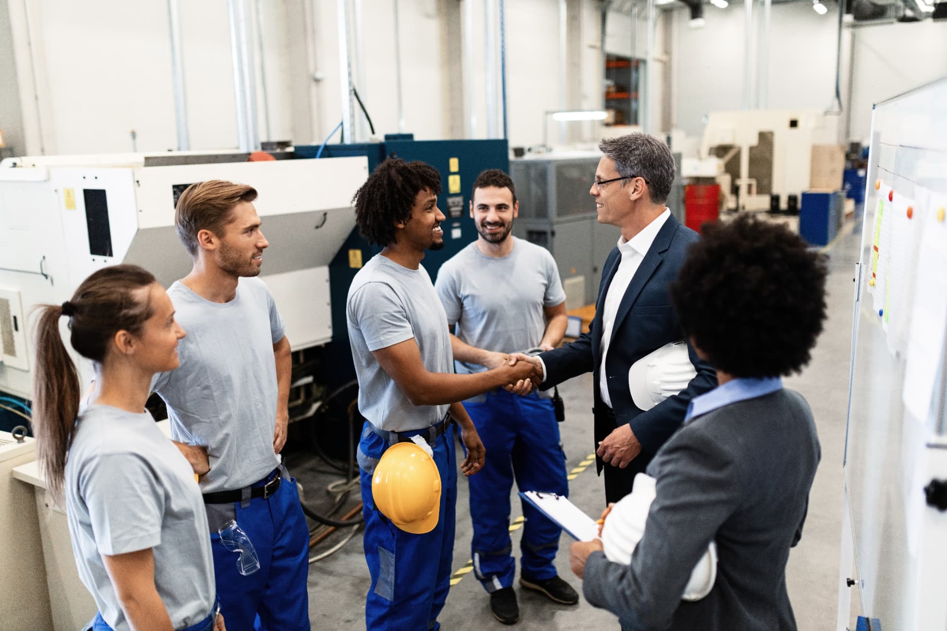 Plant manager shaking hands with a team member on the factory floor